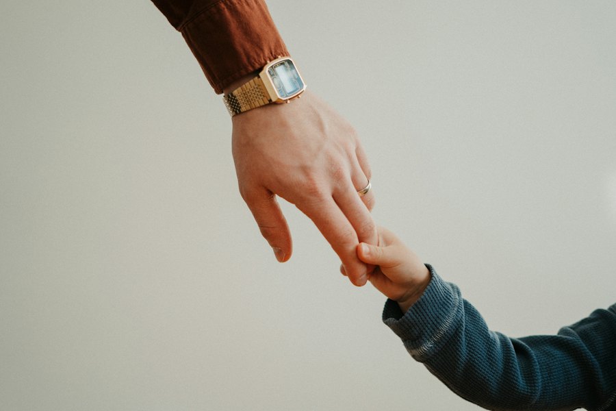 A parent holding a child's hand