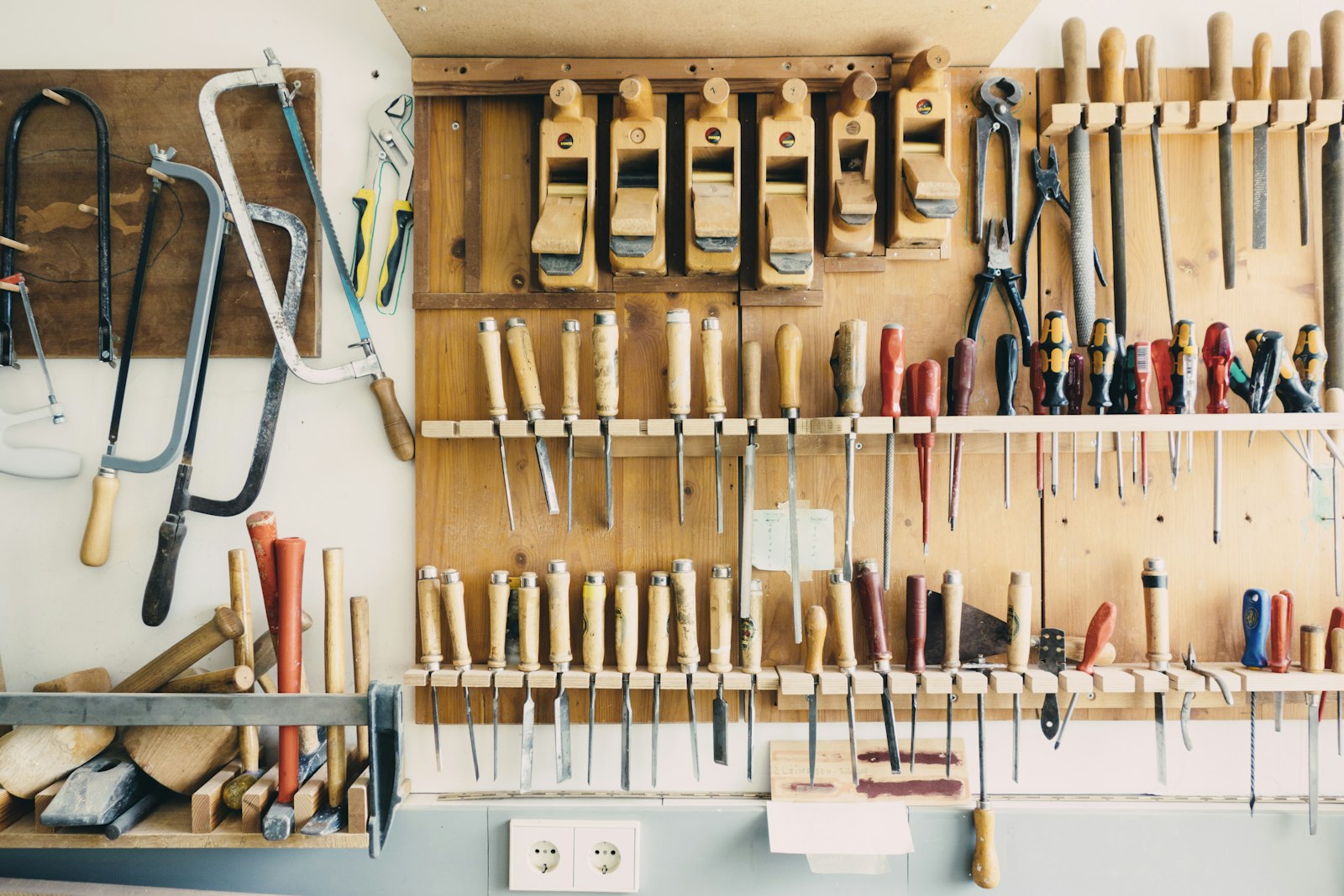A wall of hand tools hung neatly on wooden panels